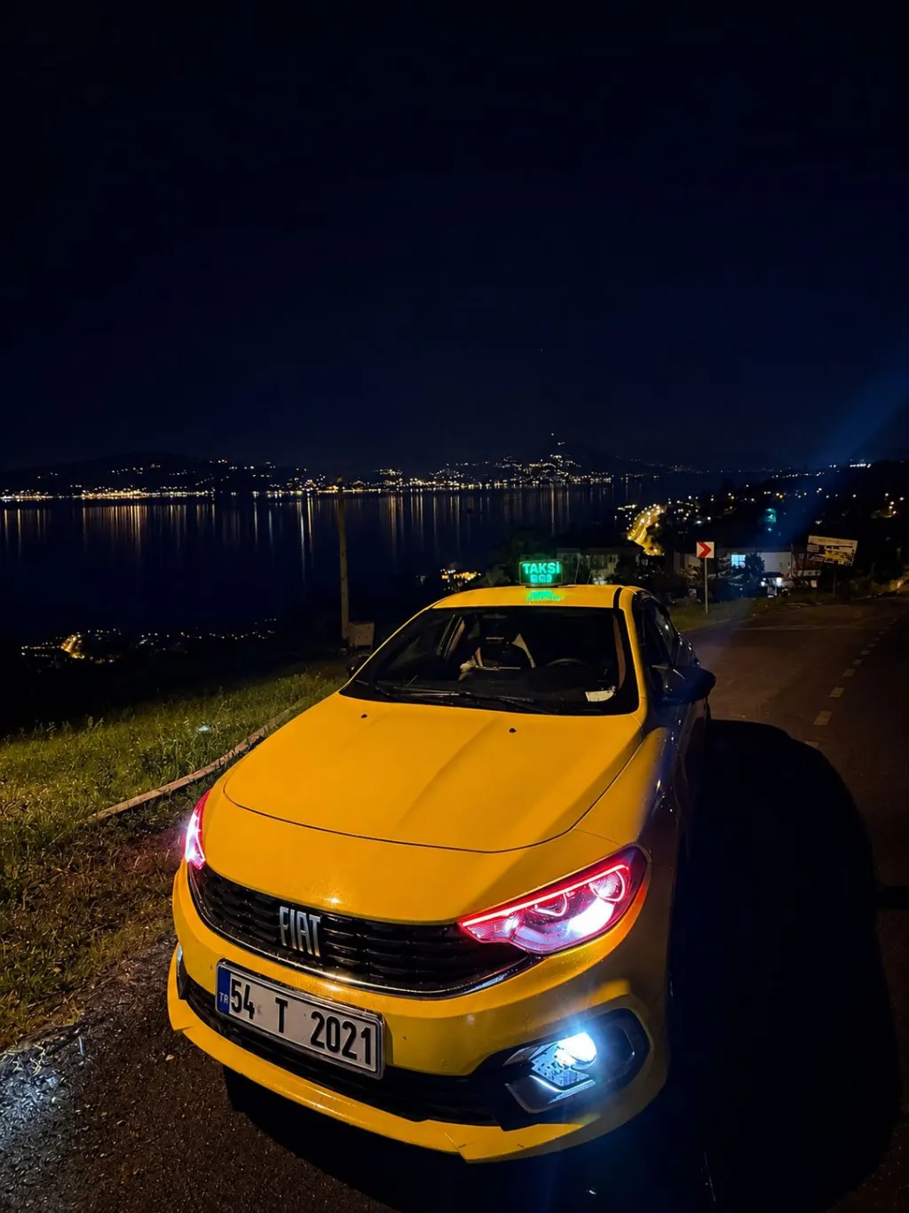 Akyazı nöbetçi taksi gece görevde - göl manzaralı yolda sarı taksi